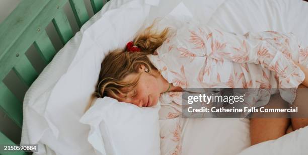top down image of a young woman enjoying a peaceful sleep on a comfortable bed - positive emotion stock pictures, royalty-free photos & images