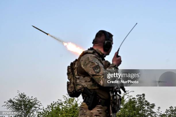 Serviceman from the Steppe Wolves all-volunteer unit is standing near a pickup equipped with Grad rocket launch tubes, which were captured from...