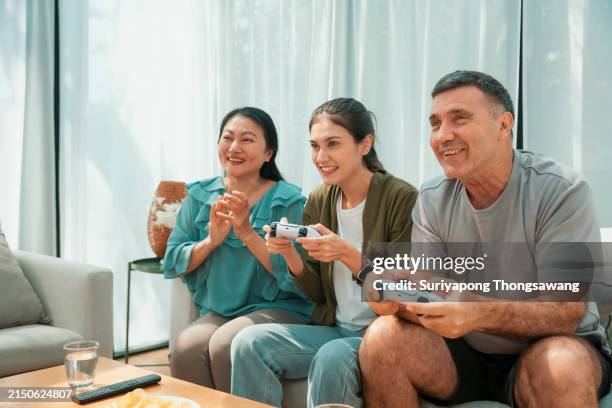 happy family playing video games in living room at home. - kid reaction portrait stock pictures, royalty-free photos & images