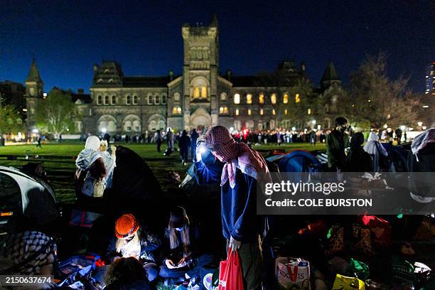Pro-Palestinian demonstrators prepare supplies at an encampment on the University of Toronto campus on May 2 in Toronto, Canada. Dozens of...