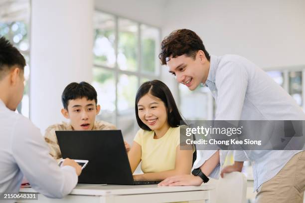group adult students gather at table in classroom to study. - tuition stock pictures, royalty-free photos & images