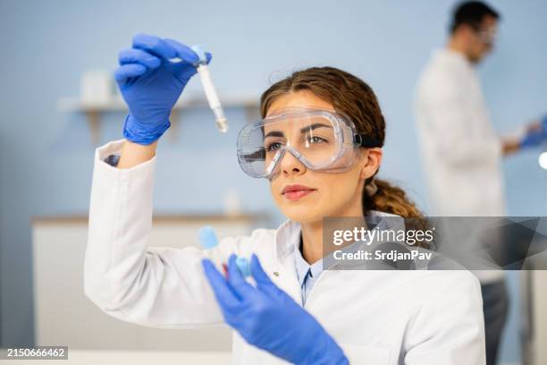 técnico de laboratório fazendo uma pesquisa - tubo equipamento de laboratório - fotografias e filmes do acervo