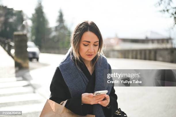 frau auf einer straße in der stadt mit handy. - bring your own device stock-fotos und bilder