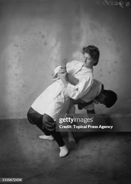 Couple demonstrating a jiu-jitsu hold, circa 1910.