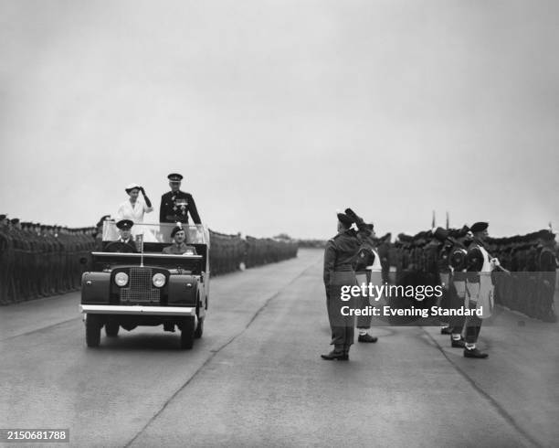 Queen Elizabeth II , Colonel in Chief of the Royal Welch Fusiliers, salutes from an open top Land Rover accompanied by Lieutenant-General Sir Hugh...