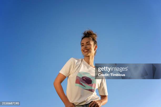 weibliches model posiert mit blick auf den himmel - bedürfnis stock-fotos und bilder