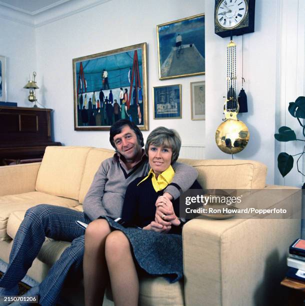 English television presenter, talk show host and journalist Michael Parkinson seated with his wife, journalist Mary Parkinson in a living room at...