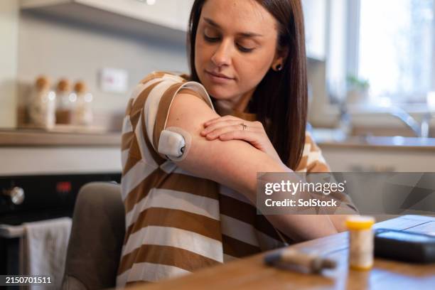 woman managing diabetes with libre - medische artikelen stockfoto's en -beelden