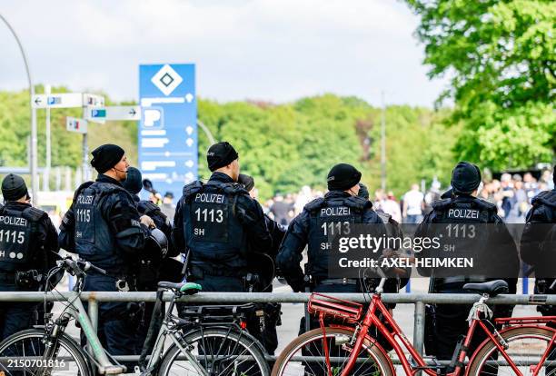 Police forces stand guard outside the Volksparkstadion as football fans arrive prior to the Bundesliga second division football match Hamburger SV vs...