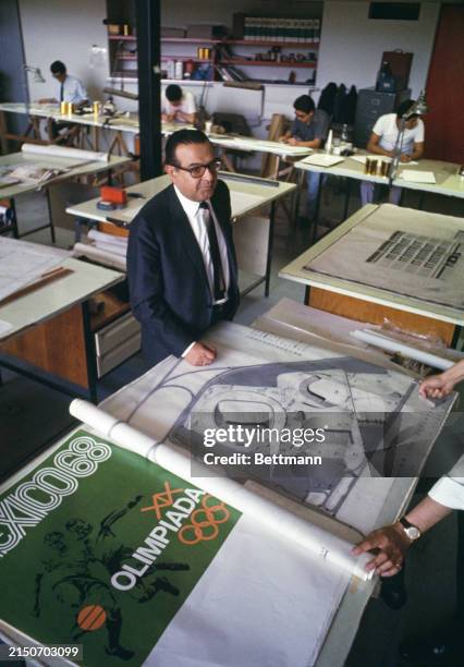 Mexican architect Pedro Ramirez Vazquez , President of the Organizing Committee for the 1968 Olympic Summer Games, looking over design plans for the...