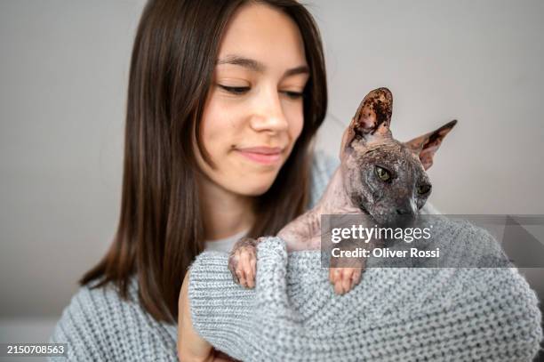 portrait of smiling woman holding hairless cat - sphynx cats stock pictures, royalty-free photos & images