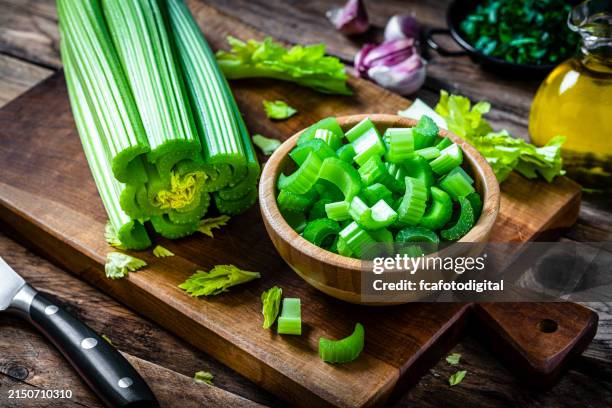 holzschale gefüllt mit frisch gehacktem bio-sellerie. - stangensellerie stock-fotos und bilder