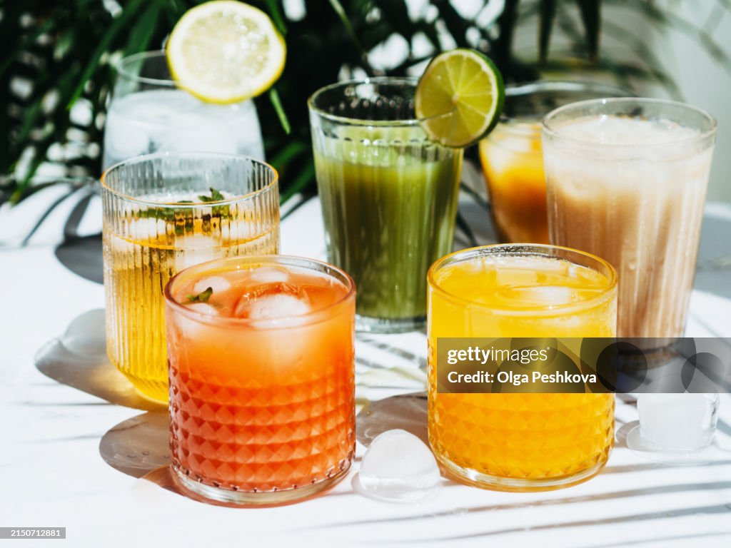 Various refreshing non-alcoholic drinks in glasses with ice.