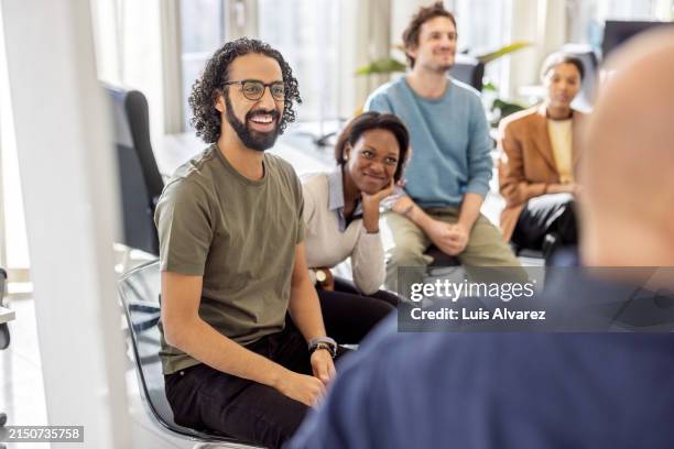 multiethnic business colleagues smiling during a presentation at startup - réunion du personnel photos et images de collection