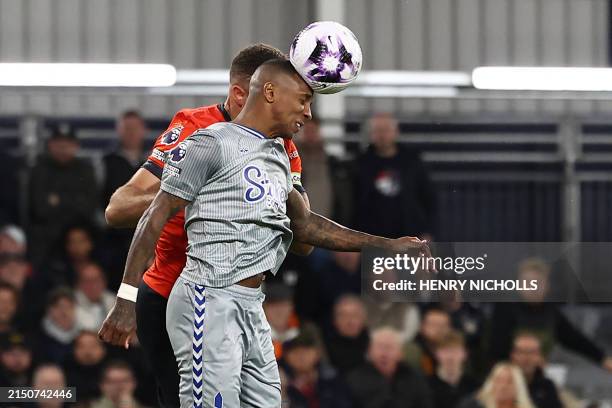Everton's English defender Ashley Young is hurt in a clash with Luton Town's English striker Carlton Morris heading this ball during the English...