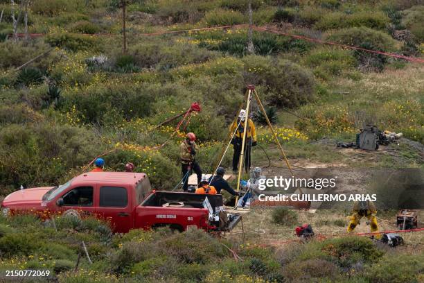 Rescue worker descends into a waterhole where human remains were found near La Bocana Beach, Santo Tomas delegation, in Ensenada, Baja California...