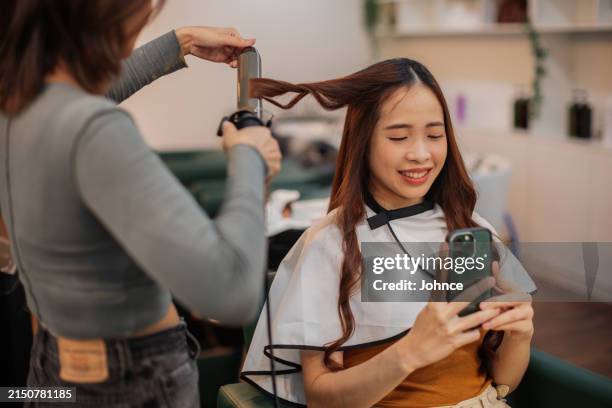smiling woman taking selfies at hair salon - hair rollers stock pictures, royalty-free photos & images