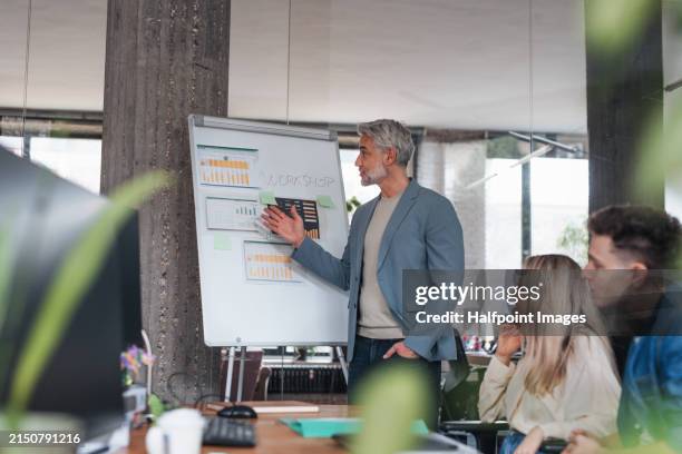 businessman giving a presentation in a business meeting. young colleagues and manager having casual discussion during meeting, workshop in office. - flujo de caja fotografías e imágenes de stock