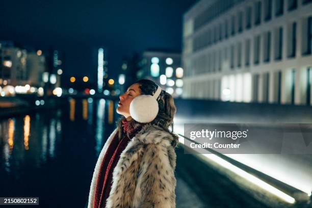 woman at spree river at night in berlin - achtsamkeit persönlichkeitseigenschaft stock-fotos und bilder