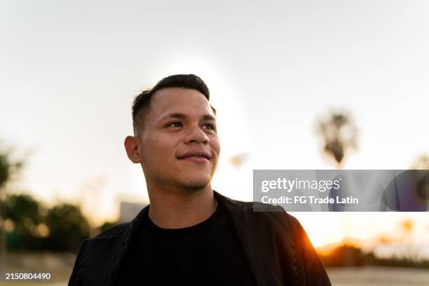 joven contemplando al aire libre - cruzar los dedos fotografías e imágenes de stock