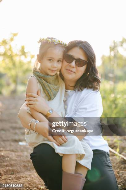 carefree young mother and daughter hugging in spring day. - kid reaction portrait stock pictures, royalty-free photos & images