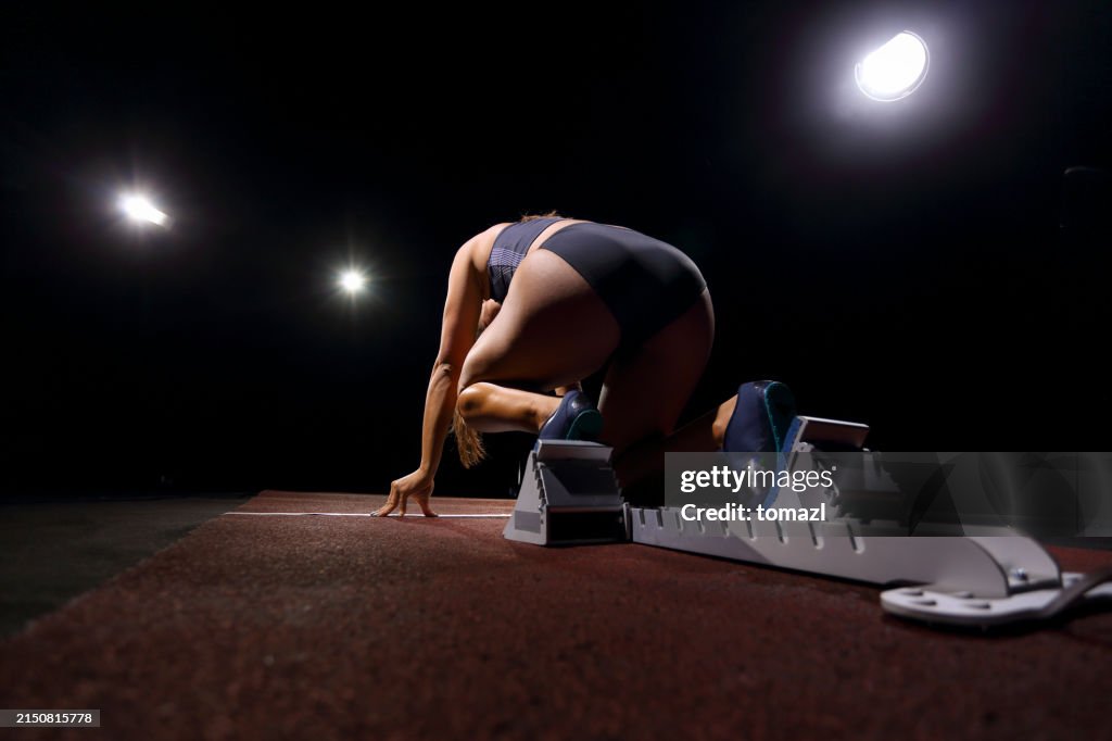Female sprinter in a starting block