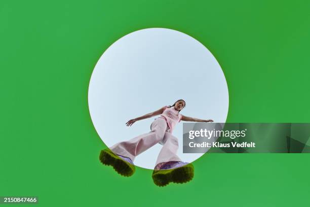 young woman mid-air in white circle - zapatos-verdes fotografías e imágenes de stock