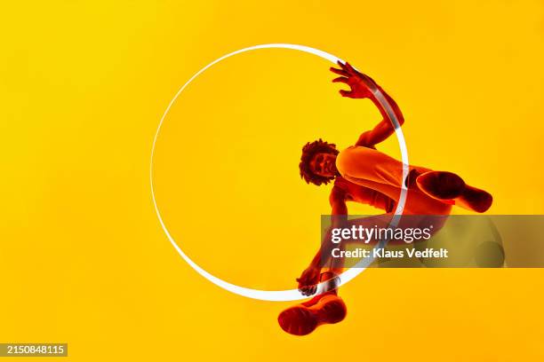 woman positioning yellow glass on white circle - zapatos-amarillos fotografías e imágenes de stock