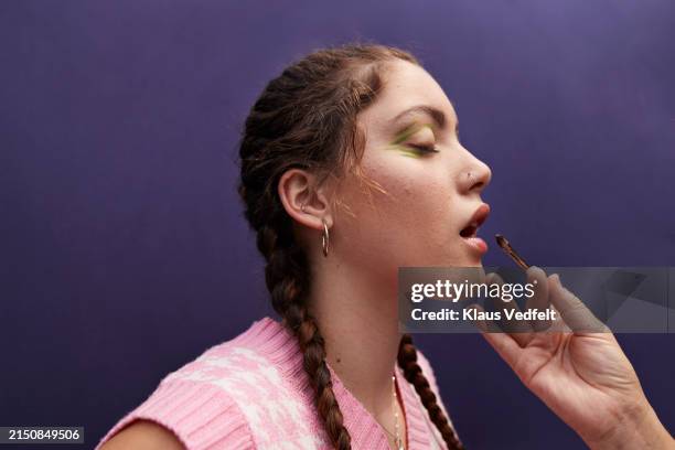 hand of make-up artist applying lipstick with brush on woman - maquilhador imagens e fotografias de stock