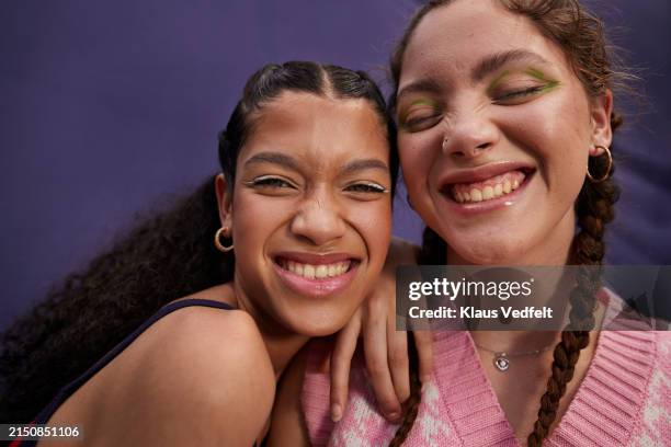 happy teenage girl with young woman - kajalschminke stock-fotos und bilder