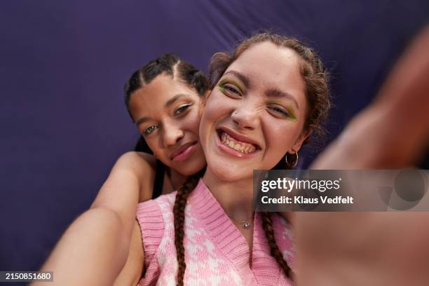 teenage girl hugging cheerful young woman taking selfie - selfie girl stockfoto's en -beelden