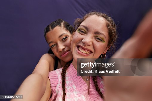 Teenage girl hugging cheerful young woman taking selfie Teenage girl hugging cheerful young woman taking selfie