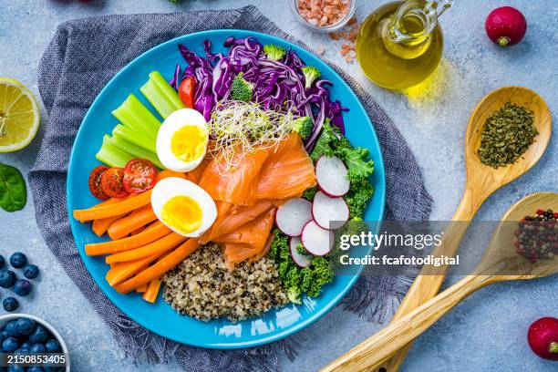 overhead view of a fresh salmon, quinoa, boiled eggs and vegetables salad plate. healthy eating and dieting concept - quinoa stockfoto's en -beelden