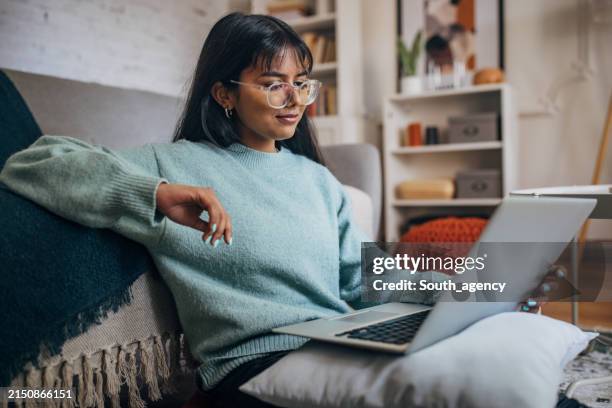 donna che si rilassa con il computer portatile nella casa moderna - computer portatile foto e immagini stock