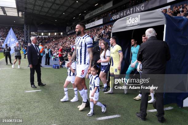 Kyle Bartley of West Bromwich Albion walks out of the players tunnel with their children ahead of the Sky Bet Championship match between West...