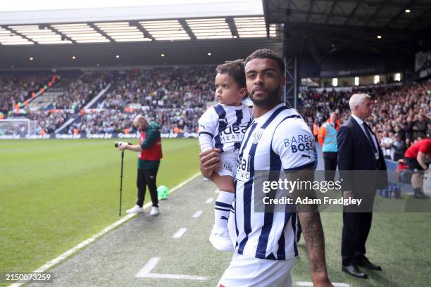 Darnell Furlong of West Bromwich Albion walks out of the players tunnel with their children ahead of the Sky Bet Championship match between West...