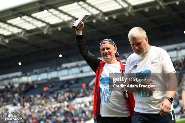 Blind Dave Heeley completes his walk to the stadium during half time in the Sky Bet Championship match between West Bromwich Albion and Preston North...