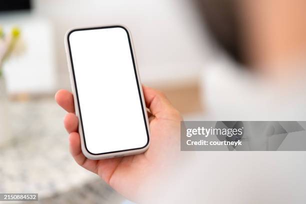 man holding a mobile phone with a blank white screen - mobile phone stock pictures, royalty-free photos & images