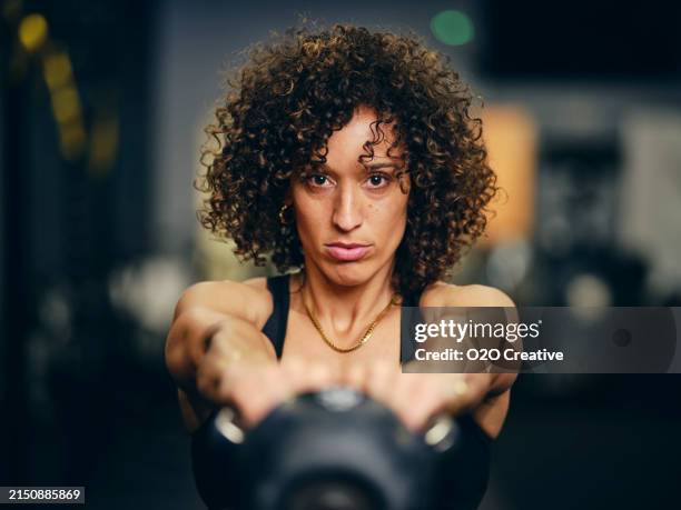 woman in a gym working out with a kettlebell - exercício anaeróbico - fotografias e filmes do acervo