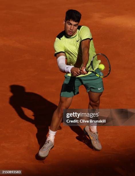 Carlos Alcaraz of Spain plays a backhand against Jan-Lennard Struff of Germany during their Men's Round of 16 match on day eight of the Mutua Madrid...