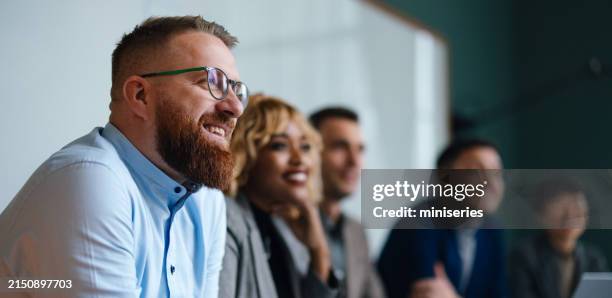 empresarios escuchando una presentación en su oficina - cooperación fotografías e imágenes de stock