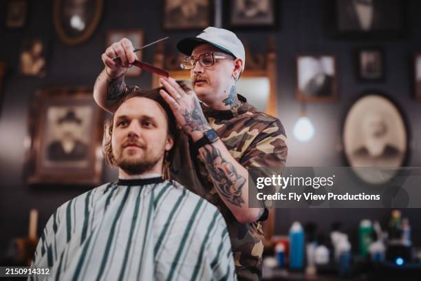 man gets his haircut at a hipster barbershop - barber shop stock pictures, royalty-free photos & images