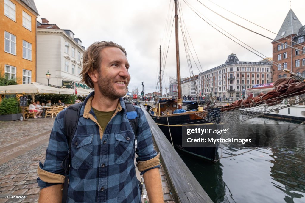 Man Enjoying a Walk by the Nyhavn Canal in Copenhagen