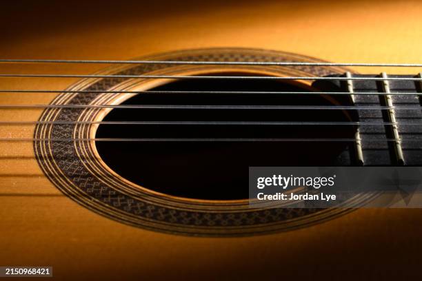 the sound hole and fretboard of an classical guitar with nylon strings - saite stock-fotos und bilder