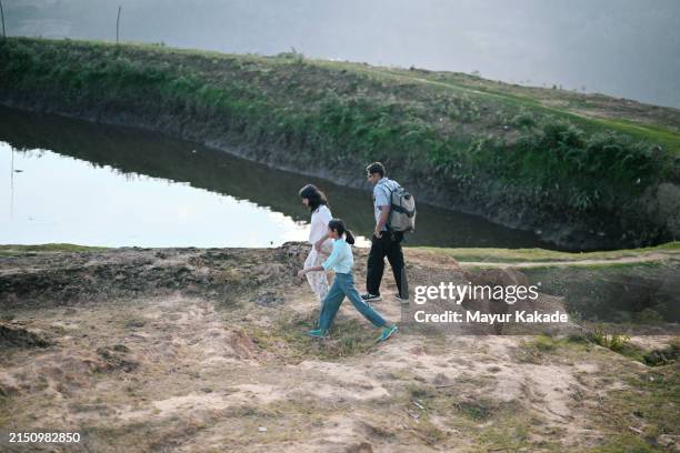 familie läuft entlang eines gewässers, während sie abgelegene dörfer in tamil nadu, indien, erkundet - alles hinter sich lassen stock-fotos und bilder