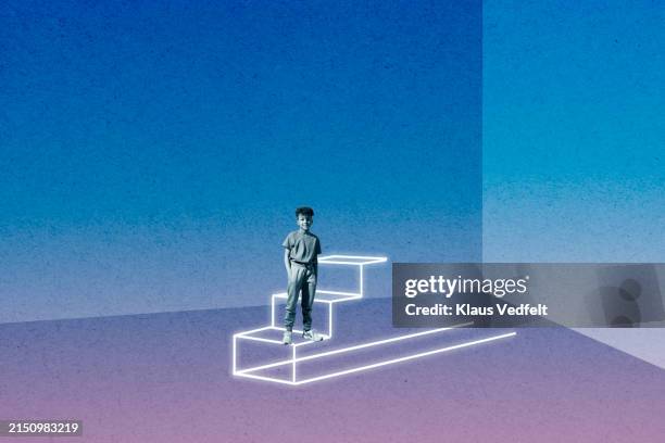 boy standing with hands in pockets on steps - ladder of success stock pictures, royalty-free photos & images