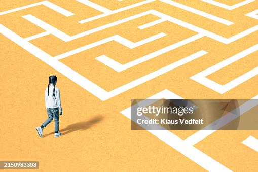 Girl walking towards maze on yellow surface Girl walking towards maze on yellow surface