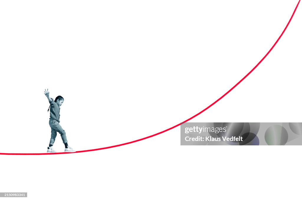 Girl balancing on red rope with arms outstretched