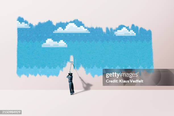 girl painting blue color on wall - initiative photos et images de collection