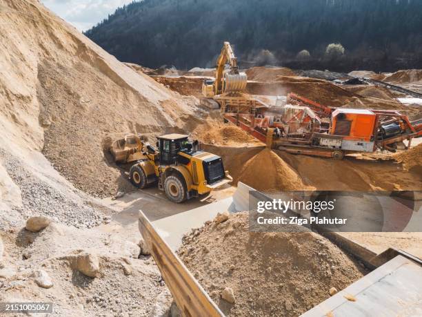aerial photo of excavator loading gravel onto a dump truck - quarry - kalksteen stockfoto's en -beelden
